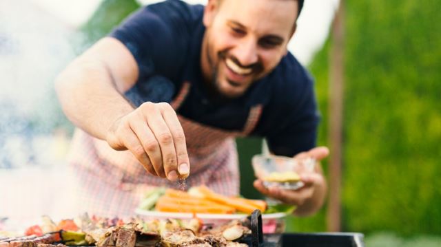 Fantastic outdoor things you can buy this spring and summer man adding food to barbecue